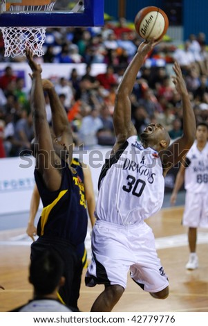 KUALA LUMPUR - DECEMBER 13: KL Dragons\' Jamal Brown (R) in a fade-away jumper, in this match against Thailand Tigers in the ASEAN Basketball League match December 13, 2009 in Kuala Lumpur.