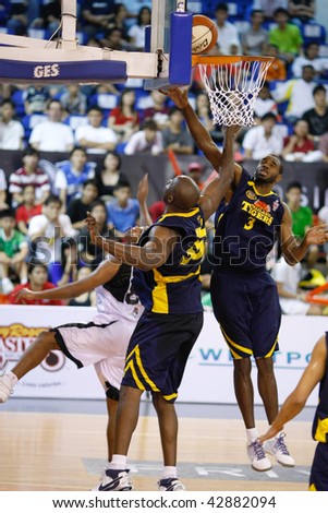 KUALA LUMPUR - DECEMBER 13: KL Dragons\' Guga (L) sneaked the ball in between the hands of the Thailand Tigers\' I. Nwankwo(C) and C. Briggs (R) in the ABL match on December 13, 2009 in Kuala Lumpur.