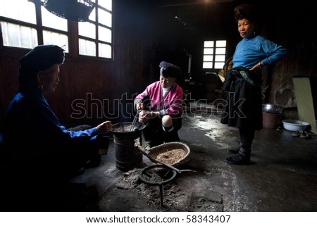 LONGJI, CHINA - MAY 21: Yao ethnic minority women in the kitchen cook the family dinner in a traditional home. May 21, 2010 in Longji, China.
