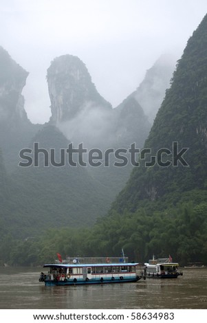 GUILIN, CHINA - MAY 22: Ferry boats carry tourist on the Li Jiang River in Guilin on May 22, 2010. The scenic Li Jiang river with the hills in the back is a popular tourist destination.