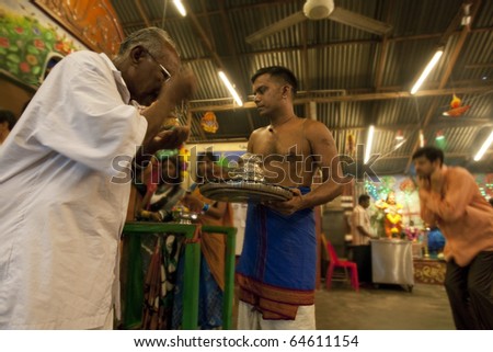 KUALA LUMPUR, MALAYSIA - NOVEMBER 5: Temple priests bless devotees on Diwali festival day on November 5, 2010 at the Hanuman Temple in Kuala Lumpur.  Diwali celebrates the triumph of good over evil.