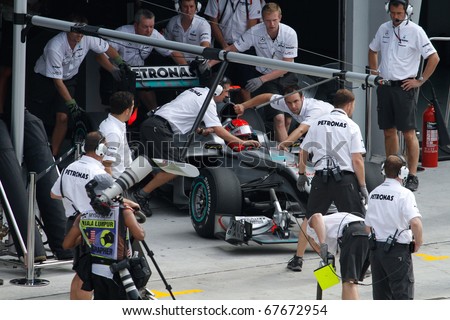 KUALA LUMPUR - APRIL 2: Mercedes\' mechanics push Michael Schumacher\'s car back into the garage after his practice run at the 2010 Petronas Malaysia F1 Grand-Prix on April 2, 2010 in Sepang, Malaysia.