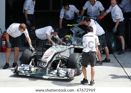 KUALA LUMPUR - APRIL 2: Mercedes\' mechanics push Nico Rosberg\'s car back into the garage after his practice run at the 2010 Petronas Malaysia F1 Grand-Prix on April 2, 2010 in Sepang, Malaysia.