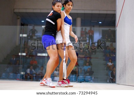 BK JALIL, MALAYSIA - MARCH 16: Delia Arnold (Malaysia) in black takes on Joshna Chinappa (India) at the CIMB KL Open Squash Championship 2011 at the National Squash Centre. March 16, 2011 in Malaysia.