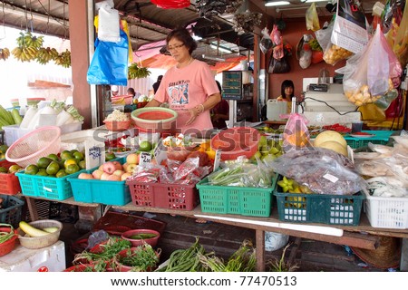 KUCHING - MAY 13: An unidentified lady packs the vegetables at her shop in town, May 13, 2011 in Kuching, Borneo Island. Most of the shops cater to the town-folks and a growing number of tourists.