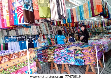 KUCHING - MAY 13: Unidentified salesperson wait for customers at their textile shop, May 13, 2011 in Kuching, Borneo Island. Most of the shops cater to the town-folks and a growing number of tourists.
