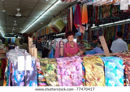 KUCHING - MAY 13: A salesperson waits for customers at her textile shop in Kuching, May 13, 2011 in Kuching, Borneo Island. Most of the shops cater to the town-folks and a growing number of tourists.