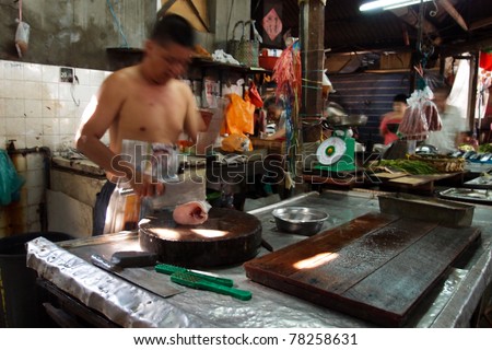KUALA LUMPUR - MAY 22: Fishmonger in a traditional Chinese wet market works at his stall on May 22, 2011 in Kuala Lumpur, Malaysia. This wet market in Chinatown was started by Chinese immigrants.