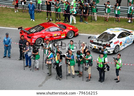 SEPANG - JUNE 19: Press photographers prepare to shoot the prize giving ceremony at the podium after the race of the Japan SUPER GT Round 3 race on June 19, 2011 in Sepang, Malaysia.