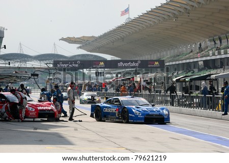 SEPANG - JUNE 19: Team Impul\'s Nissan GTR car leaves the pit-lane after tire change at the practice round of the Japan SUPER GT Round 3 race on June 19, 2011 in Sepang international Circuit, Malaysia.