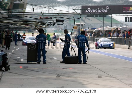 SEPANG - JUNE 19: Team Impul\'s pit-crew waits for their car to come in during the practice round of the Japan SUPER GT Round 3 race on June 19, 2011 in Sepang international Circuit, Malaysia.