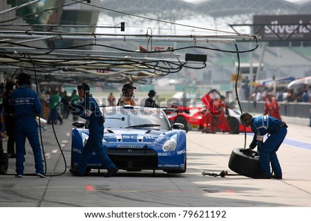 SEPANG - JUNE 19: Pit crew works on Team Impul's Nissan GT-R R35 car during the practice round of the Japan SUPER GT Round 3 race on June 19, 2011 in Sepang international Circuit, Malaysia.
