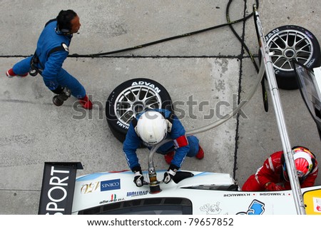 SEPANG - JUNE 19: LMP Motorsport pit crew prepares to refuel and change tires during a pit-stop of the Japan SUPER GT Round 3 race on June 19, 2011 in Sepang International Circuit, Malaysia.