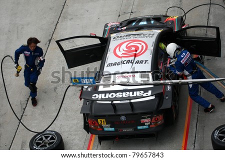 SEPANG - JUNE 19: apr team's pit crew prepares to refuel and change tires during a pit-stop of the Japan SUPER GT Round 3 race on June 19, 2011 in Sepang International Circuit, Malaysia.