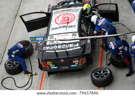 SEPANG - JUNE 19: apr team\'s pit crew prepares to refuel and change tires during a pit-stop of the Japan SUPER GT Round 3 race on June 19, 2011 in Sepang International Circuit, Malaysia.