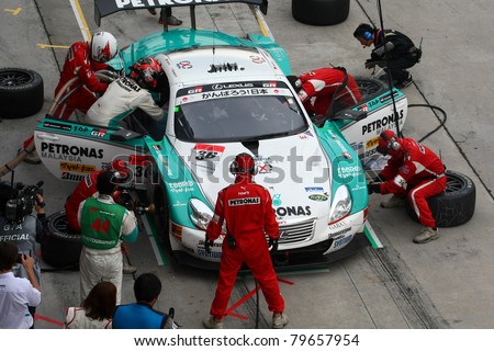 SEPANG - JUNE 19: Lexus Team Petronas Tom\'s pit crew prepares to refuel and change tires during a pit-stop of the Japan SUPER GT Round 3 race on June 19, 2011 in Sepang International Circuit, Malaysia