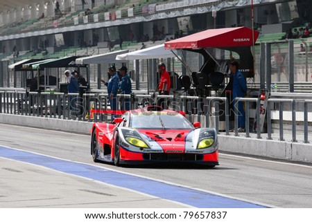 SEPANG - JUNE 19: Autobacs Racing Team Aguri\'s car exits to the tracks after refueling and tire change in the Japan SUPER GT Round 3 race on June 19, 2011 in Sepang International Circuit, Malaysia
