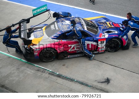 SEPANG - JUNE 18: The pit crew of Lexus Team Zent Cerumo pushes back the car into the garage in the Sepang International Circuit at the Japan SUPER GT Round 3 on June 18, 2011 in Sepang, Malaysia.