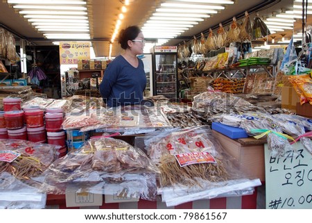 DAEPOHANG FISH MARKET - JUNE 06: A lady sells seafood products waits for customers at her shop on June 06, 2011 in Daepohang, South Korea. This market is a tourist attraction at this port town.
