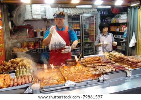 SEOUL - JUNE 06: Workers at a street food stall in Myeungdong packs food items selected by customers on June 06, 2011 in Seoul, South Korea. This area is a famous shopping area for locals and tourists