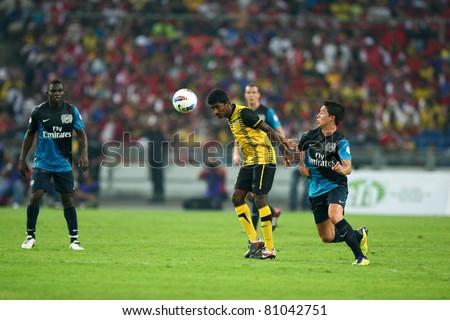 BUKIT JALIL - JULY 13: Arsenal's Samir Nasri (blue) challenges a Malaysian player on July 13, 2011 in Stadium Bukit Jalil, Malaysia. English Premier League team Arsenal is on an Asia Tour.