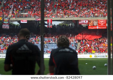 BUKIT JALIL - JULY 16: Liverpool reserve players sitting on the bench view team supporters and fans cheer in the game against Malaysia at the National Stadium on July 16, 2011, Bukit Jalil, Malaysia.