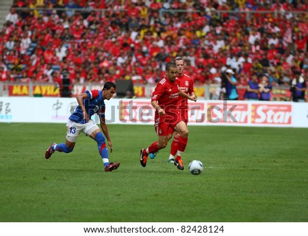 BUKIT JALIL - JULY 16: Liverpool\'s Joe Cole (red) dribbles the ball past Ahmad Fakri in the game against Malaysia at the National Stadium on July 16, 2011, Bukit Jalil, Malaysia. Liverpool won 6-3.