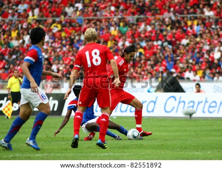 BUKIT JALIL - JULY 16 : Liverpool\'s Alberto Aquilani (red) is tackled by a Malaysian defender in their game at the National Stadium on July 16, 2011, Bukit Jalil, Malaysia. Liverpool won 6-3.