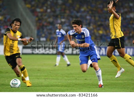 BUKIT JALIL, MALAYSIA - JULY 21: Chelsea\'s Yuri Zhirkov (blue) dribbles the ball past Malaysian players at the National Stadium on July 21, 2011 in Bukit Jalil, Malaysia. Chelsea won 1-0.