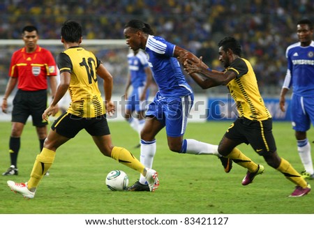 BUKIT JALIL, MALAYSIA - JULY 21: Chelsea's Didier Drogba (blue) dribbles the ball past Malaysian players at the National Stadium on July 21, 2011 in Bukit Jalil, Malaysia. Chelsea won 1-0.