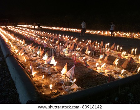 PUCHONG, MALAYSIA - AUGUST 27: Prayer offerings for the ancestors, consisting of joss-sticks, candles and food line the grounds at the \'hungry ghost festival\' in Puchong, Malaysia on August 27, 2011.
