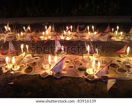PUCHONG, MALAYSIA - AUGUST 27: Prayer offerings for the ancestors, consisting of joss-sticks, candles and food line the grounds at the \'hungry ghost festival\' in Puchong, Malaysia on August 27, 2011.