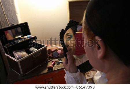 AMPANG, MALAYSIA – OCT 05: A Chinese Opera actress applies face makeup before her show at the Lam Thian Kiong Temple celebrating the ‘Nine Emperor Gods’ Festival on October 05, 2011 in Ampang, Malaysia.
