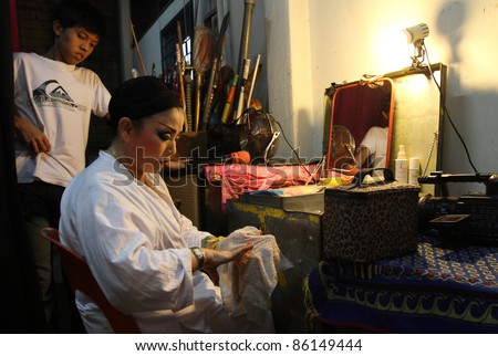 AMPANG, MALAYSIA – OCT 05: A Chinese Opera actress makes up her finger-nails before her show at the Lam Thian Kiong Temple celebrating the ‘Nine Emperor Gods’ Festival on October 05, 2011 in Ampang, Malaysia.