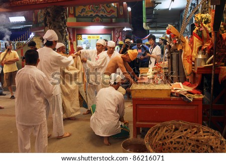 AMPANG – OCT 05: Devotees prepares to robe the priest to start the fire-walking ceremony at the Lam Thian Kiong Temple during the ‘Nine Emperor Gods’ Festival on October 05, 2011 in Ampang, Malaysia.