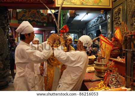 AMPANG – OCT 05: Devotees adorns the headgear for the priest to start the fire-walk event at the Lam Thian Kiong Temple during the ‘Nine Emperor Gods’ Festival on October 05, 2011 in Ampang, Malaysia.