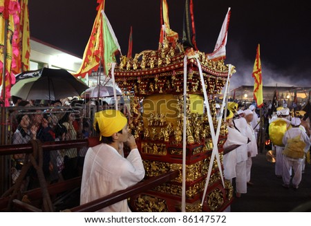 AMPANG, MALAYSIA – OCT 05: Taoist devotees carry religious items for the fire-walk ceremony at the Lam Thian Kiong Temple during the annual ‘Nine Emperor Gods’ Festival on October 05, 2011 in Ampang, Malaysia.