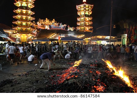 AMPANG, MALAYSIA – OCT 05: Devotees collect the charcoal believed to be blessed after the fire-walk at the Lam Thian Kiong Temple during the ‘Nine Emperor Gods’ Festival on October 05, 2011 in Ampang, Malaysia.