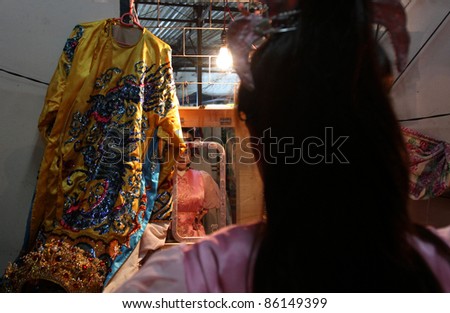 AMPANG, MALAYSIA – OCT 05: A Chinese Opera actress applies makeup backstage before her show at the Lam Thian Kiong Temple celebrating the ‘Nine Emperor Gods’ Festival on October 05, 2011 in Ampang, Malaysia.