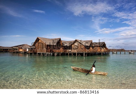 SABAH, MALAYSIA - SEPT 10: A sea gypsy returns home by boat in Mabul Island on September 10, 2011 in Sabah, Malaysia. Sea gypsies live in houses built on stilts planted on the shallow coral seas.