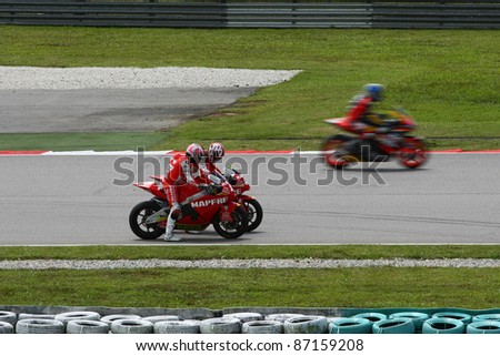 SEPANG, MALAYSIA - OCTOBER 21: Moto2 riders from Mapfre Aspar Team discusses on track at the free practice session at the Shell Advance Malaysian GP 2011 on October 21, 2011 at Sepang, Malaysia.