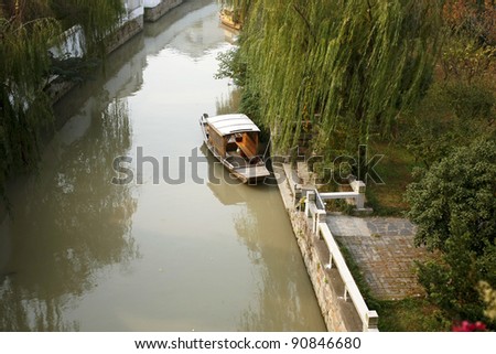 SUZHOU, CHINA - NOVEMBER 23: A boat moors on beside of the canal that leads into the city on November 23, 2011 in Suzhou, China. This canal dates back to 514 BC and is an imporant tourist destination.