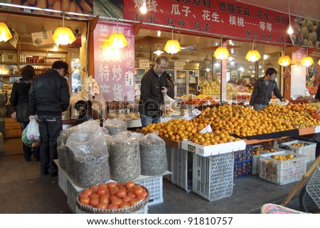 HANGZHOU, CHINA - NOVEMBER 26: Morning shoppers buy fresh farm produce in a wet market on November 26, 2011 in Hangzhou, China. Traditionally, men in Hangzhou shop and cook in the kitchen at home.
