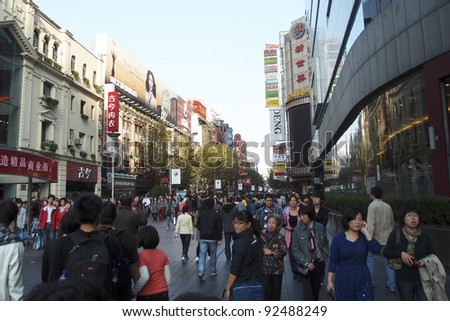 SHANGHAI, CHINA - NOVEMBER 27: Tourists and shoppers crowd the famous Nanjing Street shopping district on November 27, 2011 in Shanghai, China. Shanghai is a financial powerhouse in modern China.