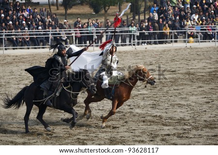 WUXI, CHINA - NOVEMBER 25: Knights on horseback fight out an ancient war in an outdoor theatre on November 25, 2011 in Wuxi, China.The scene portrays the war of the three kingdoms from 220AD to 280AD.