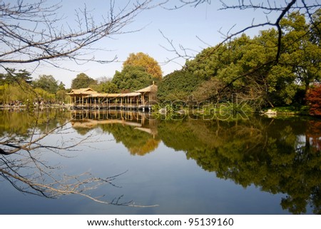 Serene and tranquil lake, reflecting a building at the West Lake in Hangzhou, China.