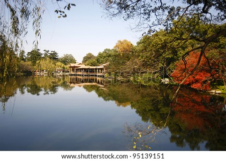 Serene and tranquil lake, reflecting a building at the West Lake in Hangzhou, China.