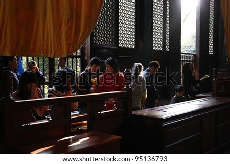HANGZHOU, CHINA - NOVEMBER 26: Devotees pray in the Hall of Medicine Buddha at the Lingyin Temple on November 26, 2011 in Hangzhou, China. Buddhism is enjoying a revival in modern liberal China.