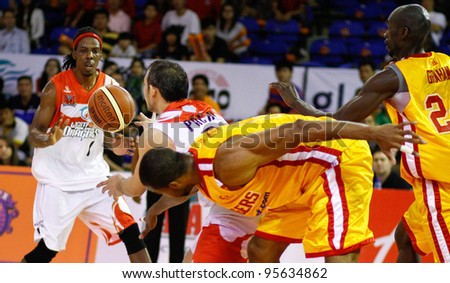 KUALA LUMPUR - FEBRUARY 19: Malaysian Dragons players (white) grab the loose ball from the Singapore Slingers (yellow) at the ASEAN Basketball League match on Feb 19, 2012 in Kuala Lumpur.