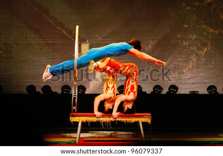 SHANGHAI, CHINA - NOVEMBER 28: A team of of gymnasts from the world famous Shanghai acrobats perform jumping act for tourist on stage on November 28, 2011 in Shanghai, China.